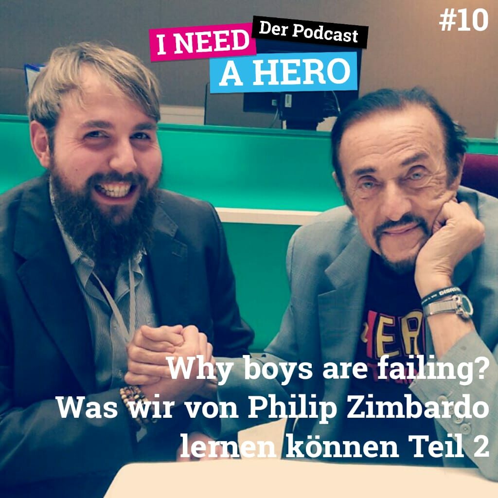 Zwei Männer reichen sich die Hand und lächeln. Unten mittig Schriftzug "Why boys are failing? Was wir von Philip Zimbardo lernen können Teil 2". Oben Schriftzug in verschienenen Farben: "I need a Hero - Der Podcast"