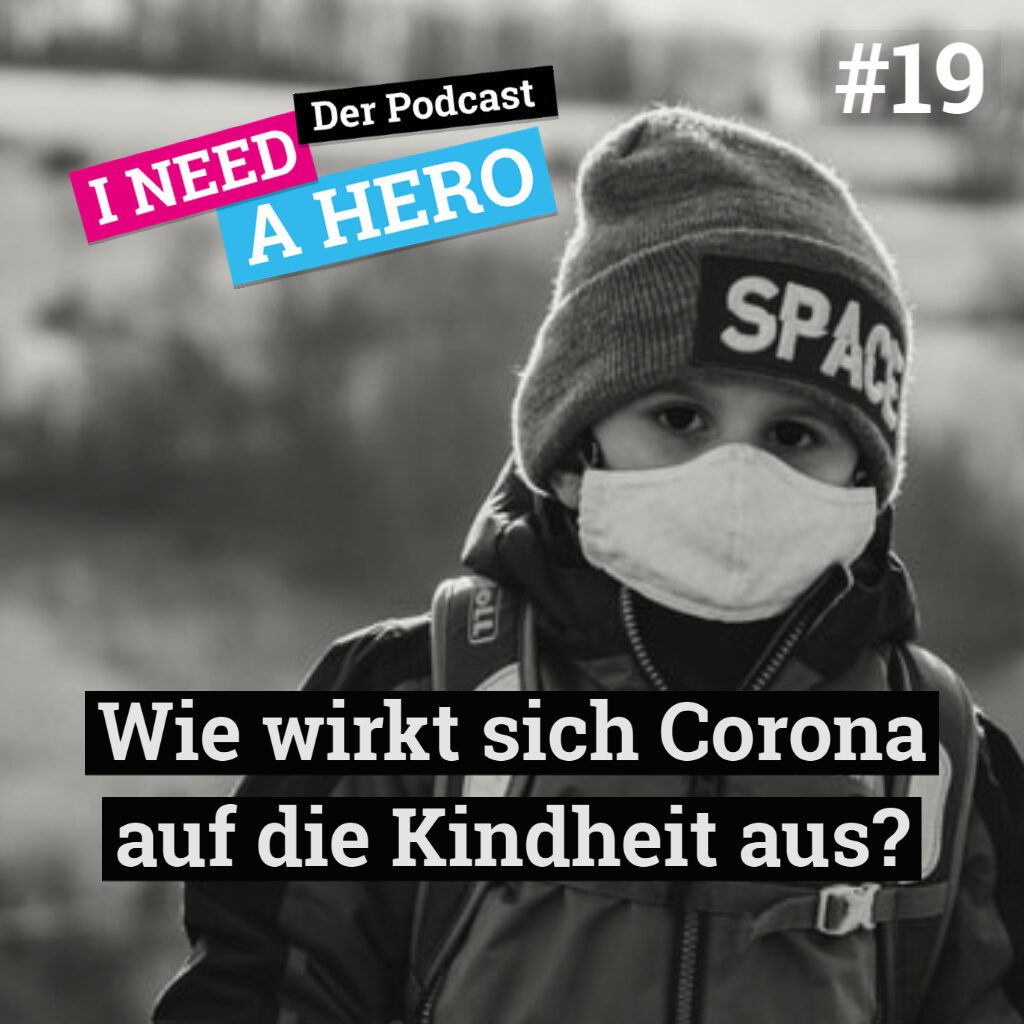 Kind mit Mütze und medizinischer Maske. Unten mittig Schriftzug "Wie wirkt sich Corona auf die Kindheit aus?". Links oben Schriftzug in verschienenen Farben: "I need a Hero - Der Podcast"