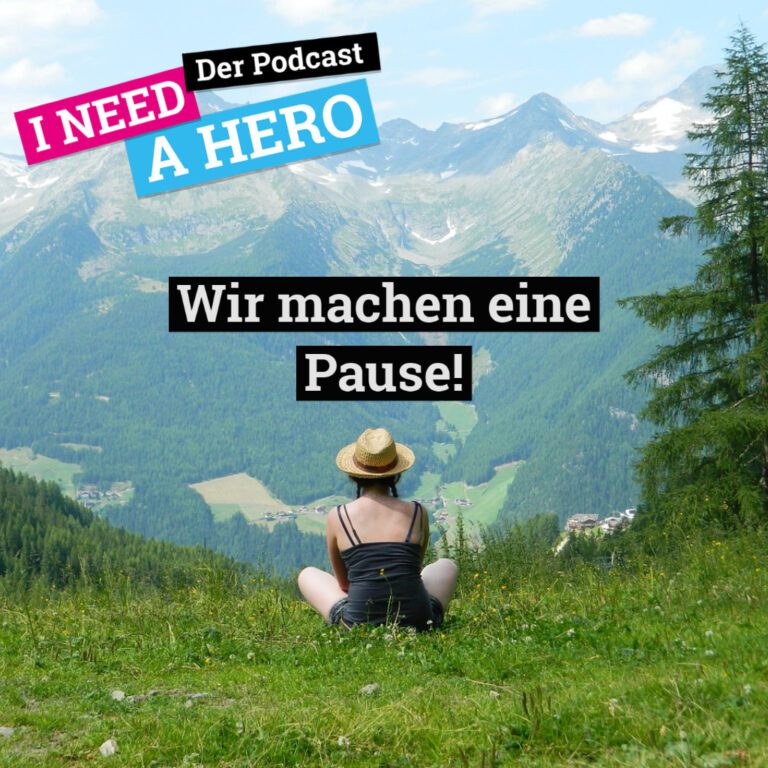 Mädchen mit Strohhut auf Wiese in den Bergen. Mittig Schriftzug "Wir machen eine Pause!". Links oben Schriftzug in verschiedenen Farben: "I need a Hero - Der Podcast"