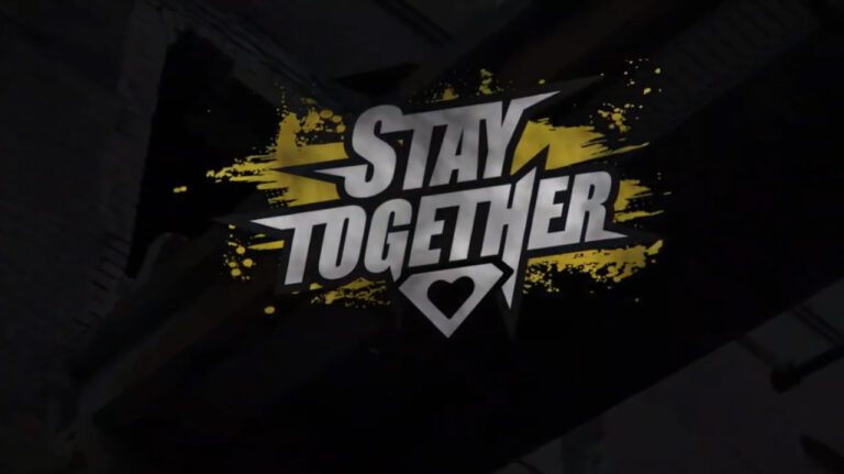 Ein mit gelben Farbflecken umrandetes Logo auf schwarzem Grund: "Stay Together"