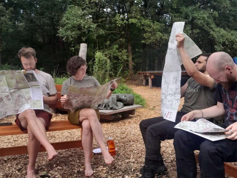 Leute an der Wildnisschule studieren Landkarten.